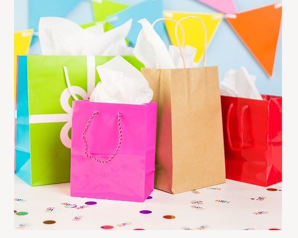 colorful gift bags against blue background with colorful pennant banner